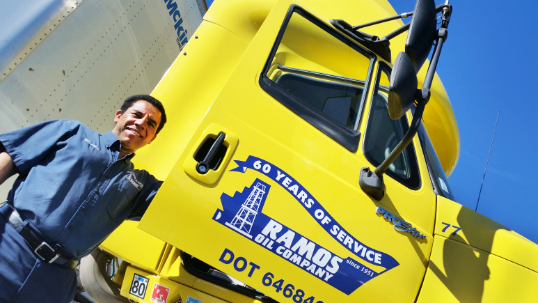 Driver standing with Ramos Oil Company delivery truck.